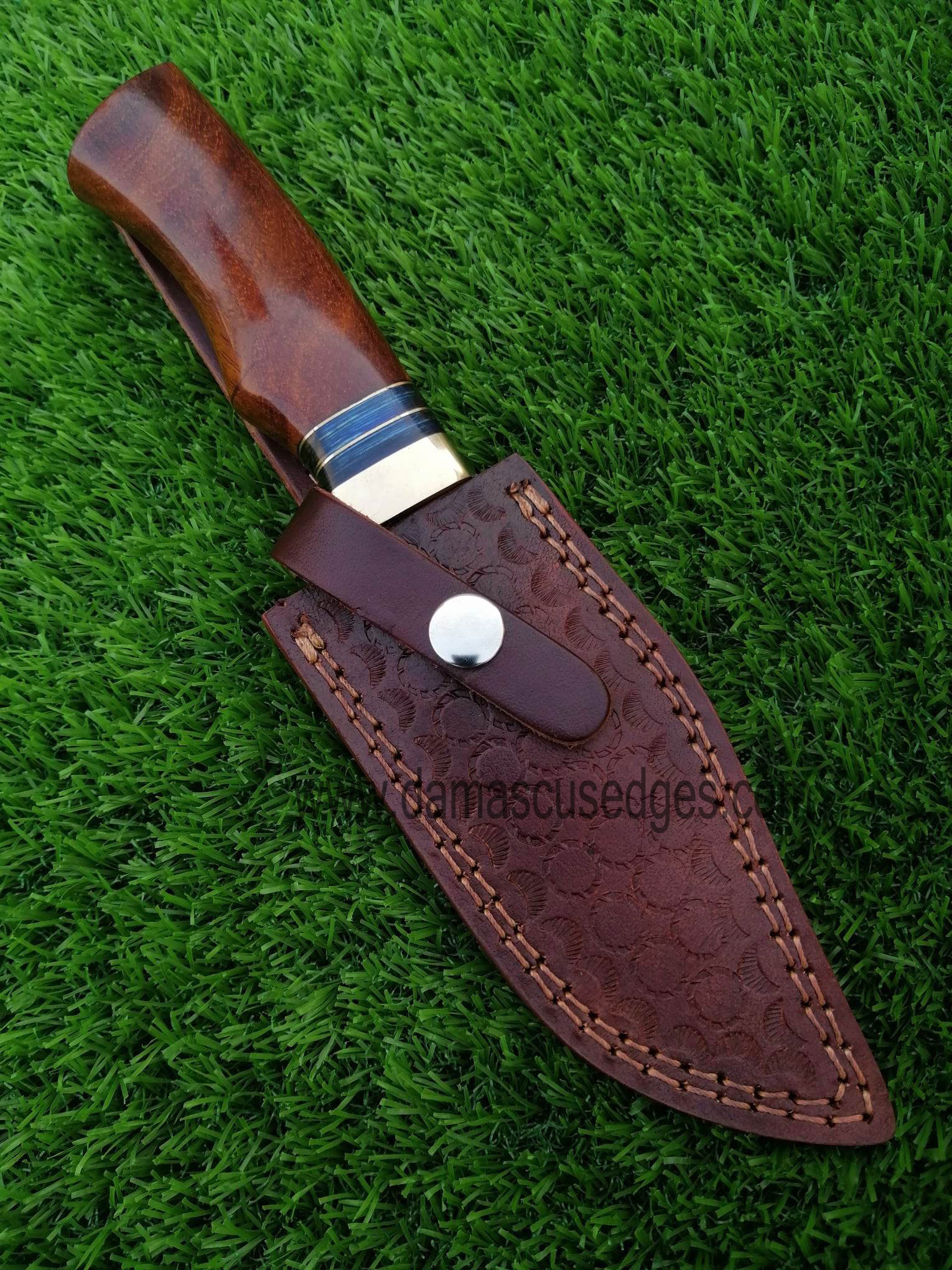 de-hunting20 The Damascus steel knife snugly nestled in its handmade leather sheath.
