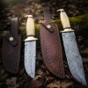 Hand-forged Damascus hunting knives with polished bone handles and leather sheaths – custom crafted by Damascus Edges.