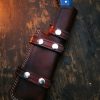 Leather sheath with custom-forged tracker knife on rustic wooden bench – Damascus Edges