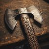 Hand-forged Viking axe with carved Norse warrior handle and etched double blade on rustic wooden bench – custom American bladesmith craftsmanship by Damascus Edges.